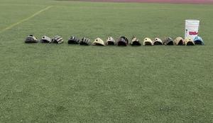 a line of baseball gloves and a bucket