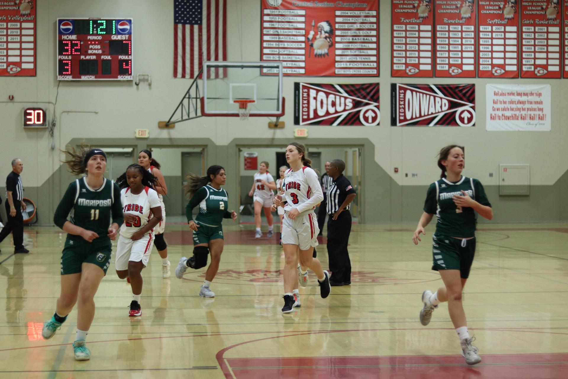 varsity girls playing basketball against mariposa