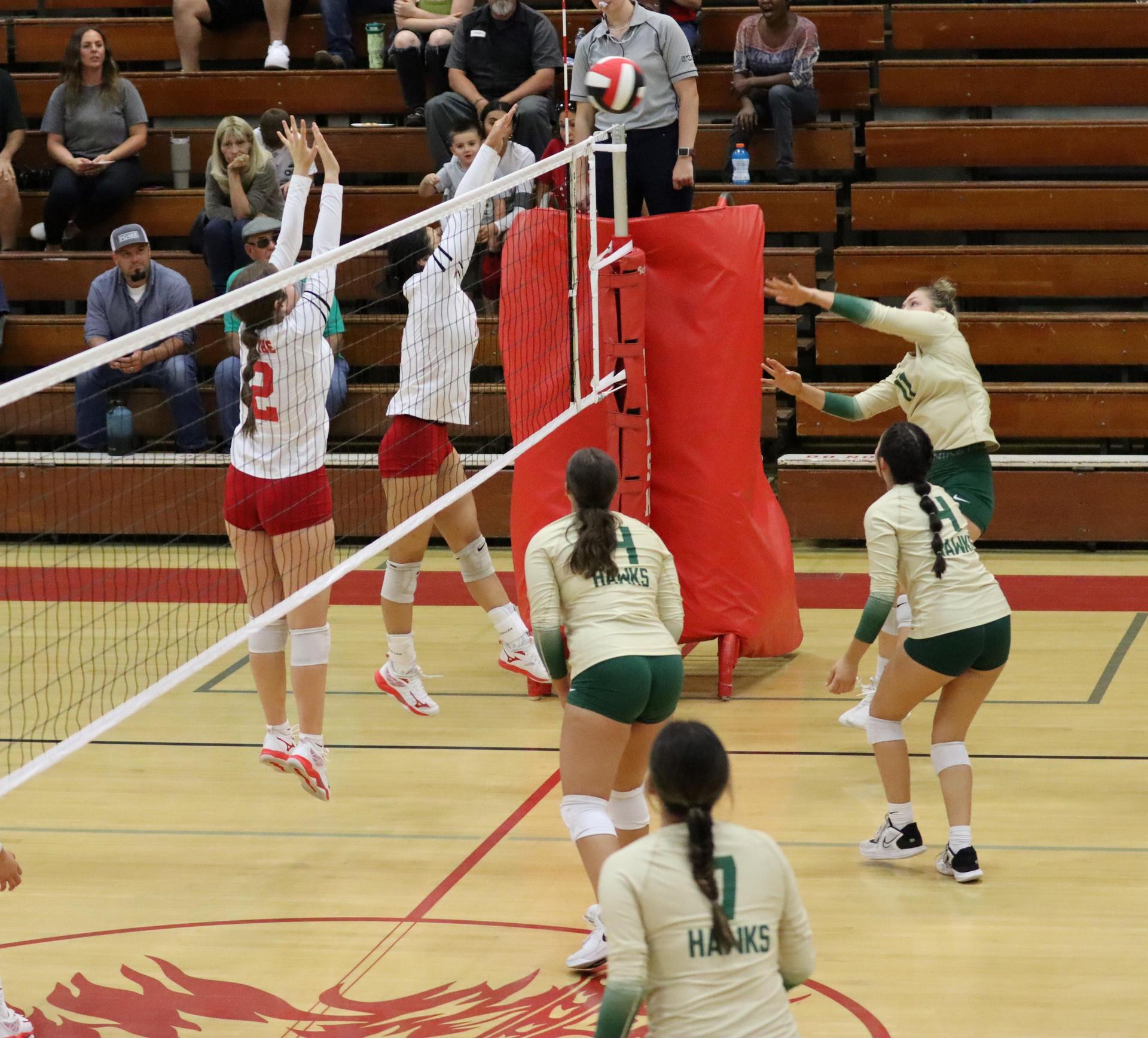 varsity volleyball players in action against liberty