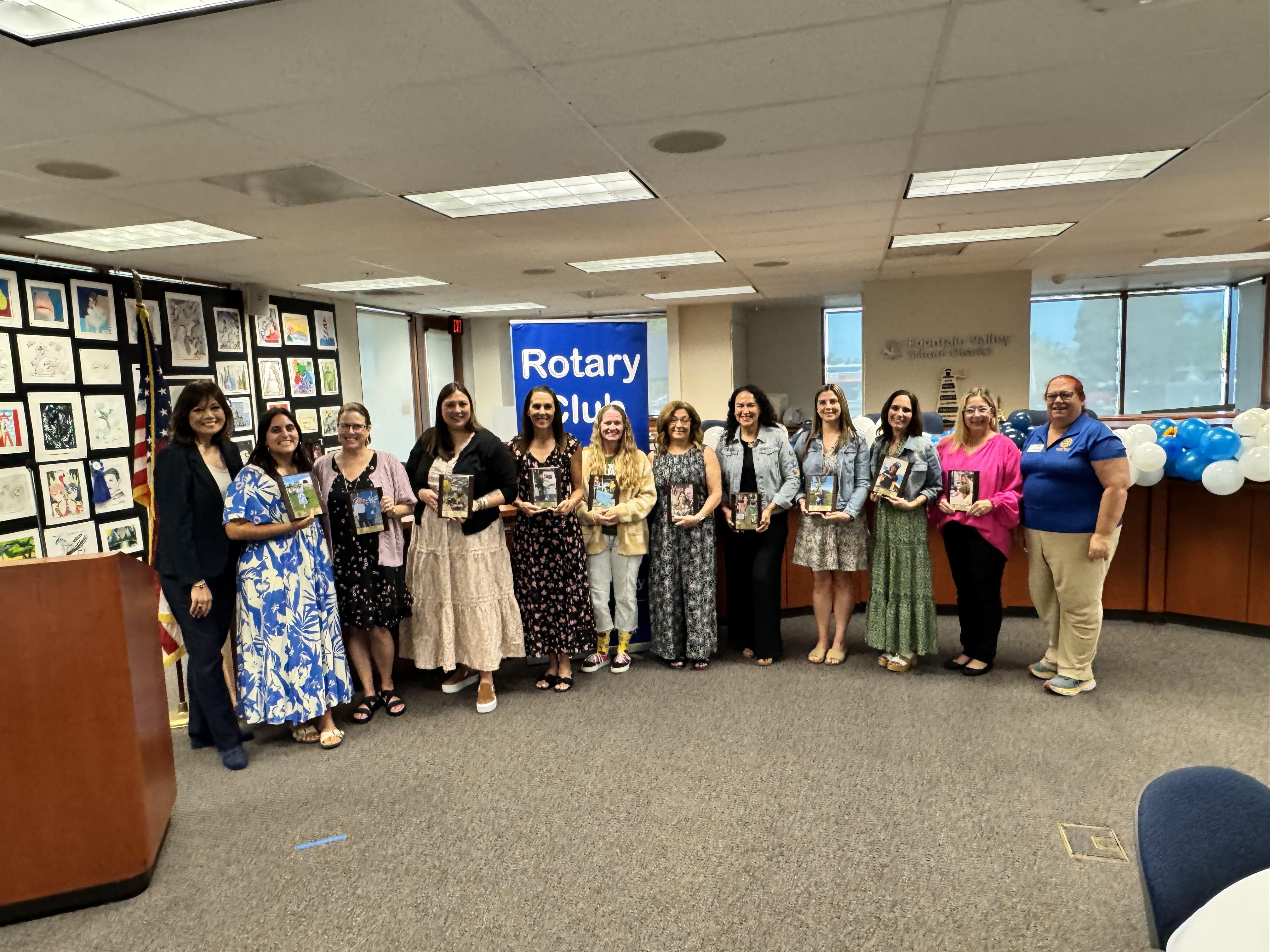 Group of award recipients posing with plaques at an event.