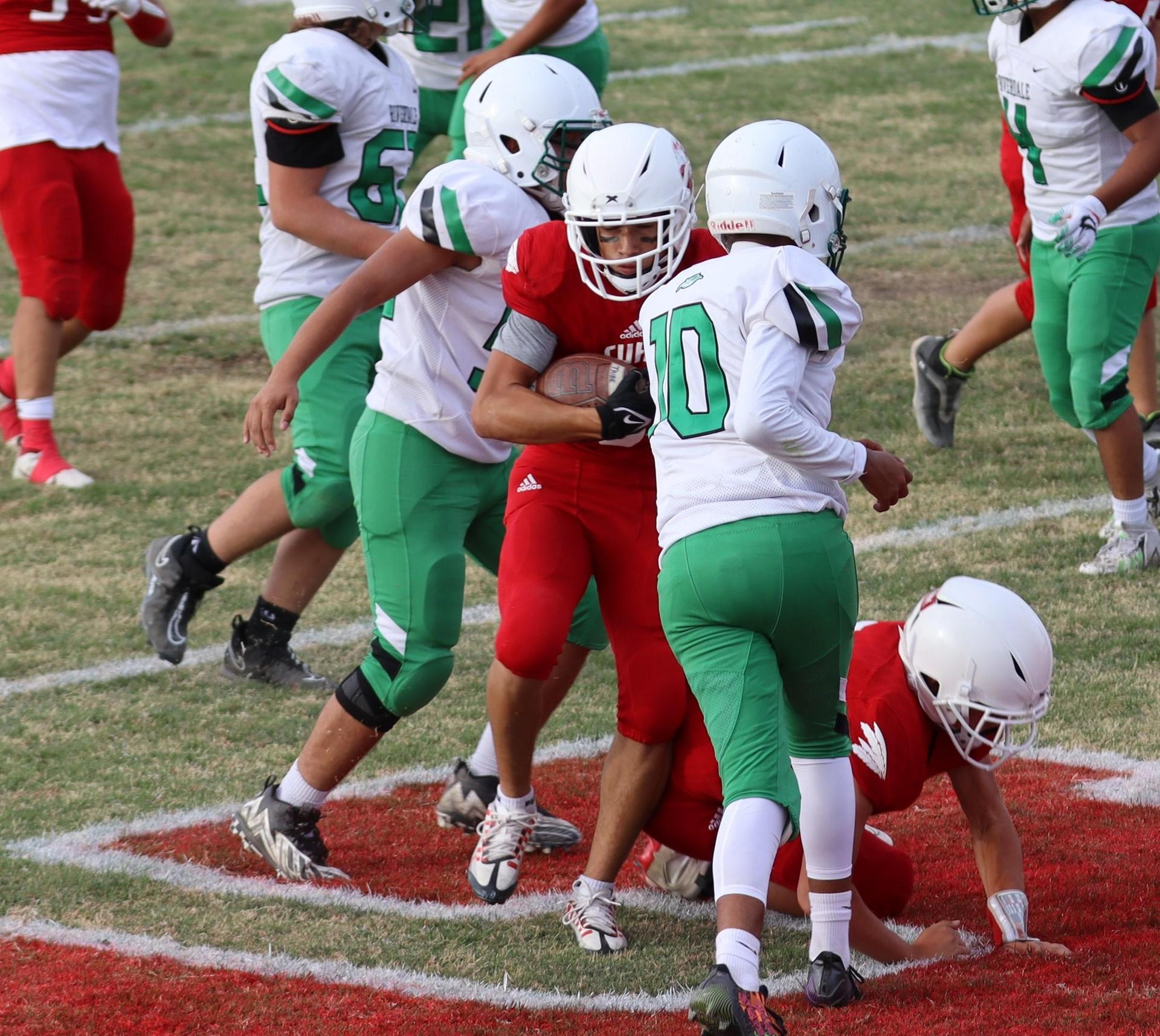  junior varsity football players in action against riverdale