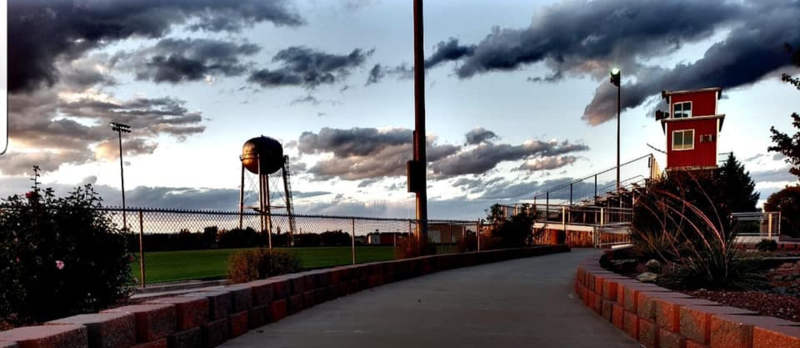 football field at sunset with the town water tower in the distance