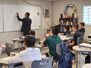 Rabbi Silverman writes on the board while teaching 8th grade about shofar.