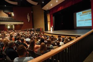 TK staff gather in the auditorium for staff opening day ceremonies.