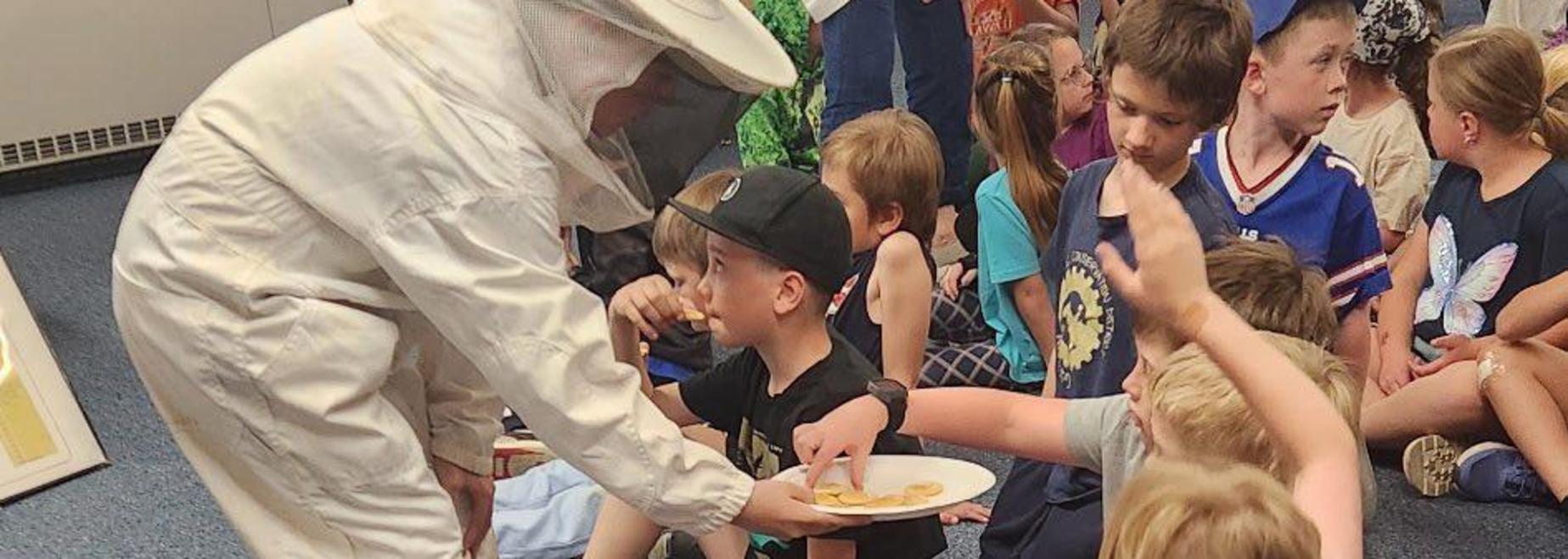 Kids engaged in a group activity with one child lying on the ground.