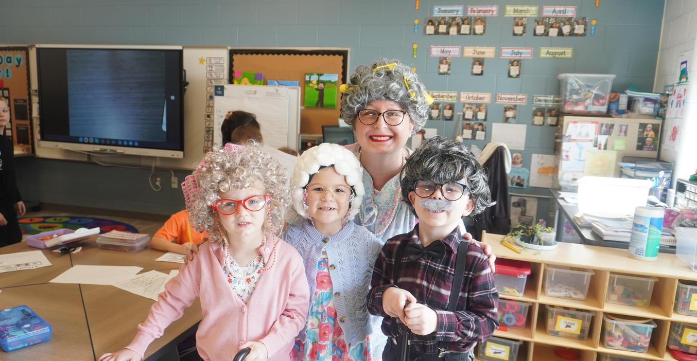 A teacher and three students dress up as old folks for 100th day.