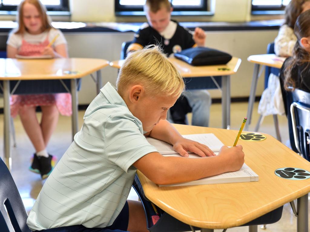 A student writing at his desk.