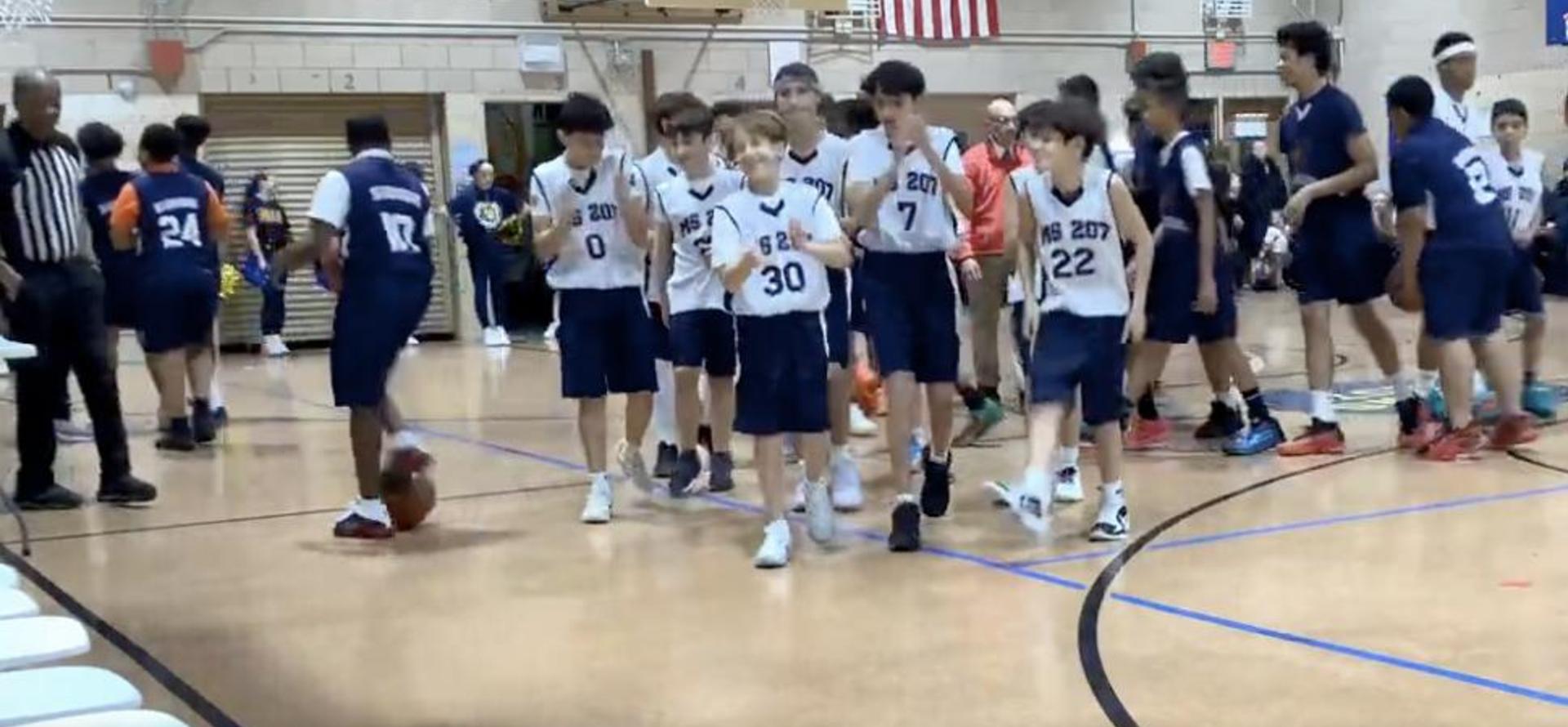 Youth basketball players walking on the court during a game.