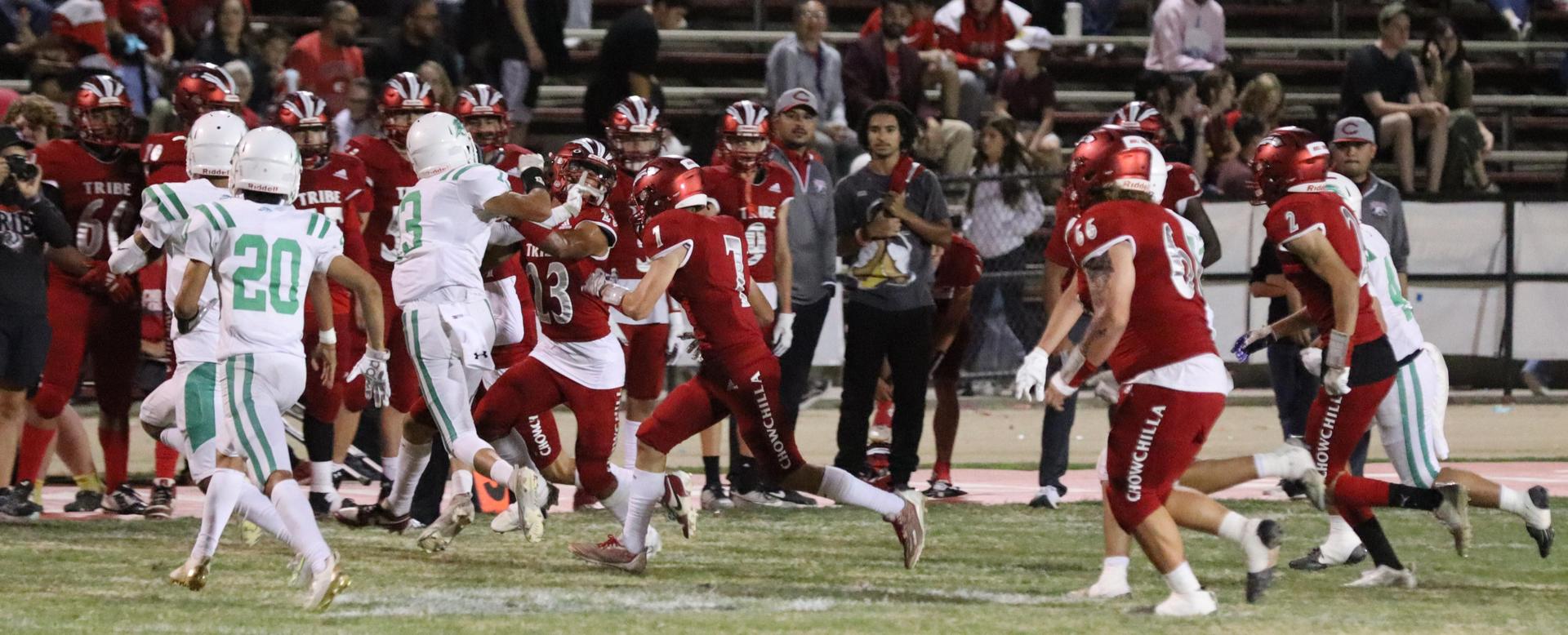 varsity football players in action against Riverdale