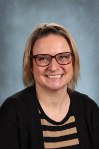 Happy woman with short hair and glasses, wearing a striped top.