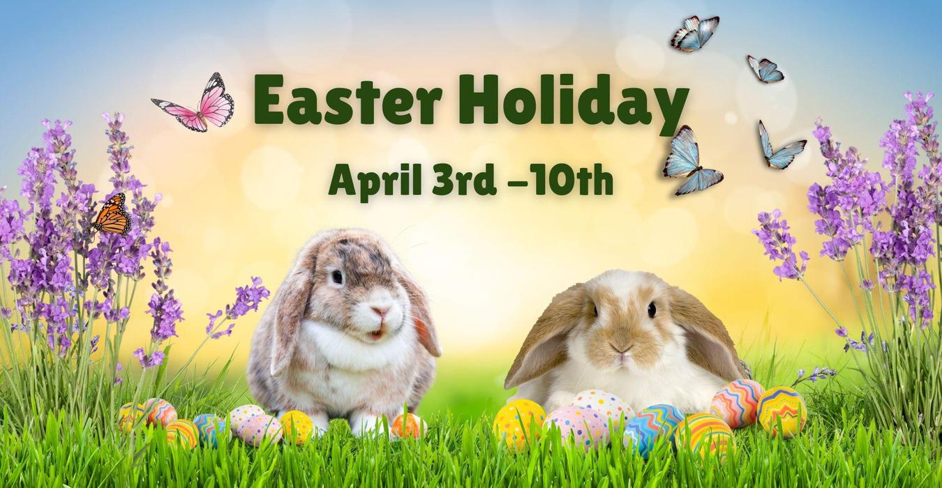 Two rabbits sitting in grass surrounded by Easter eggs and flowers.  Schools are closed from April 3rd through April 10th.