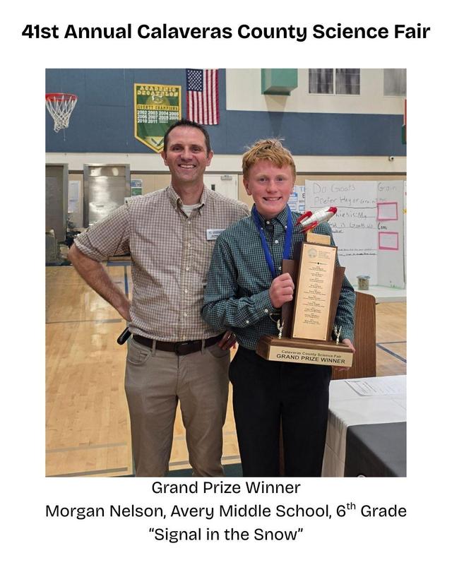 man standing with a boy holding a trophy