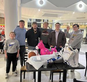Student council posed in the food court of mall with purchases
