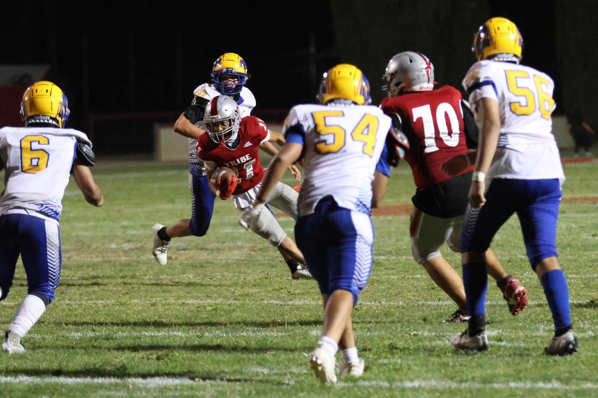 Varsity football players in action against Parlier 84