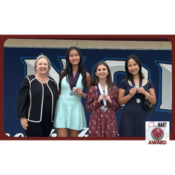 A woman and three students posing for a photo