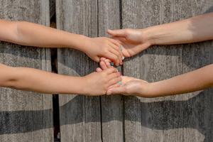 Adult hands holding a child's hands