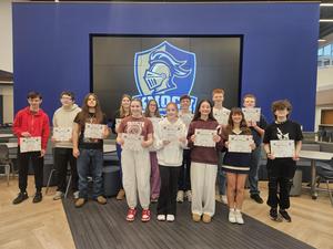 group of students holding up certificates in front of knoch logo