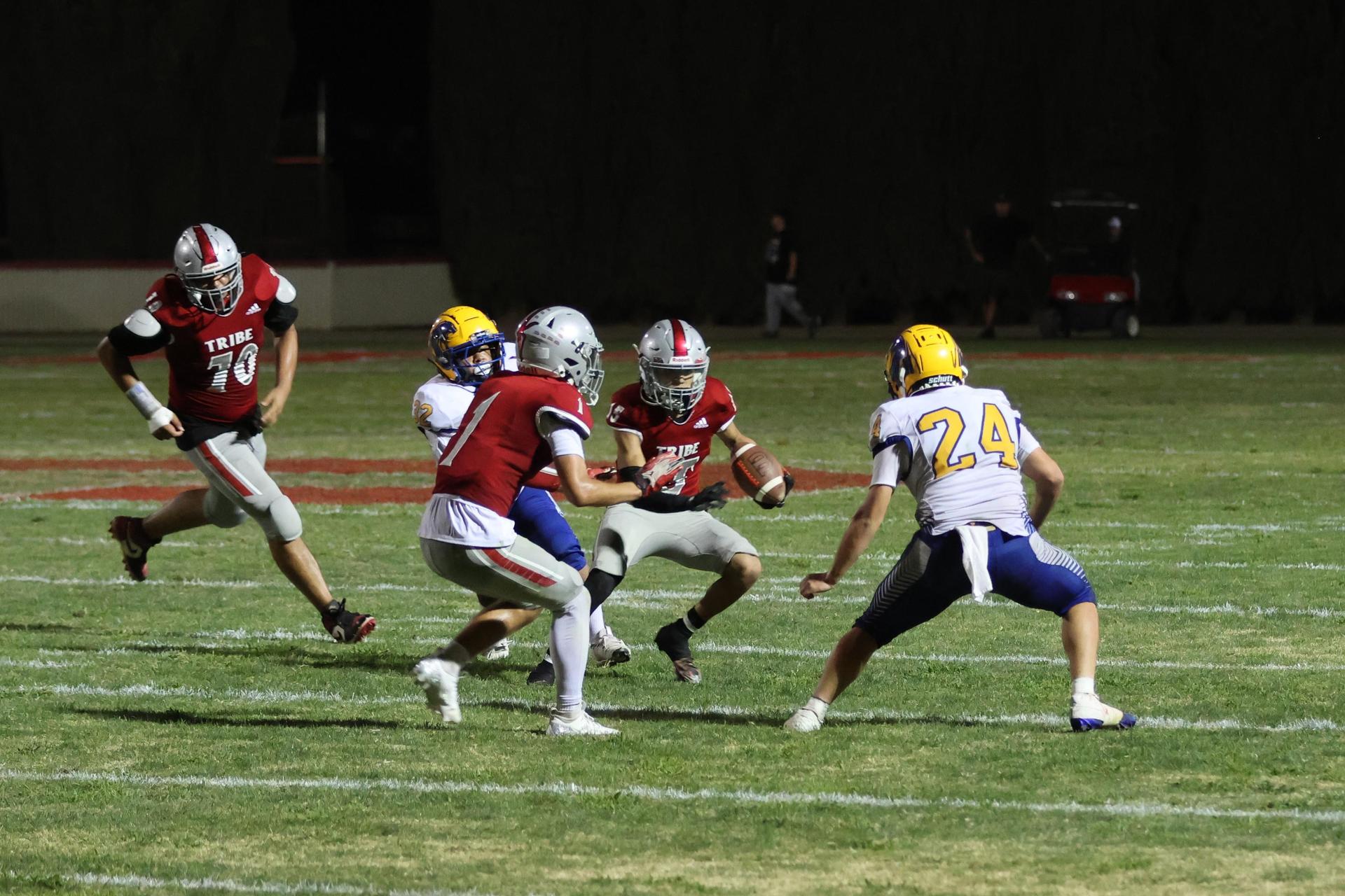 Varsity football players in action against Parlier 15