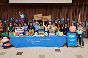 Laura Gonzalez-Garcia, the helpful honda team, and numerous staff behind a table full of school supplies