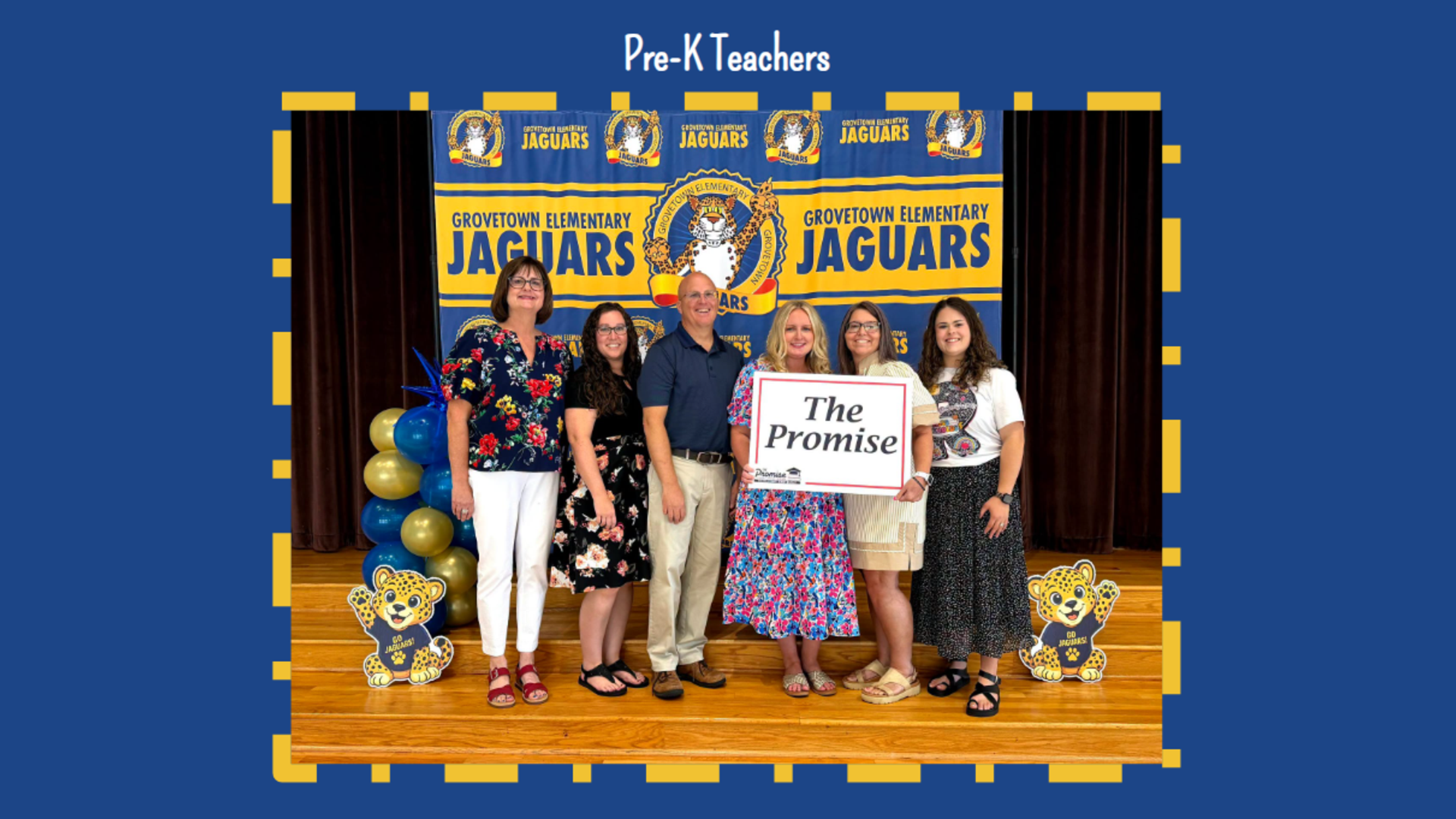 Group of Pre-K teachers posing with a sign and decorations at a school event.