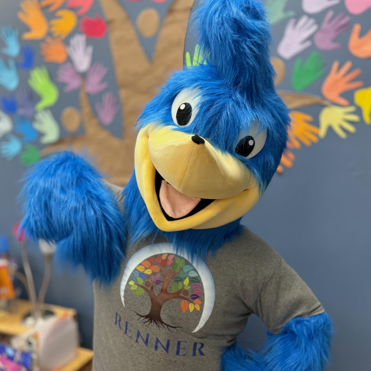 Roadrunner pointing to his tshirt with the Renner Academy Logo