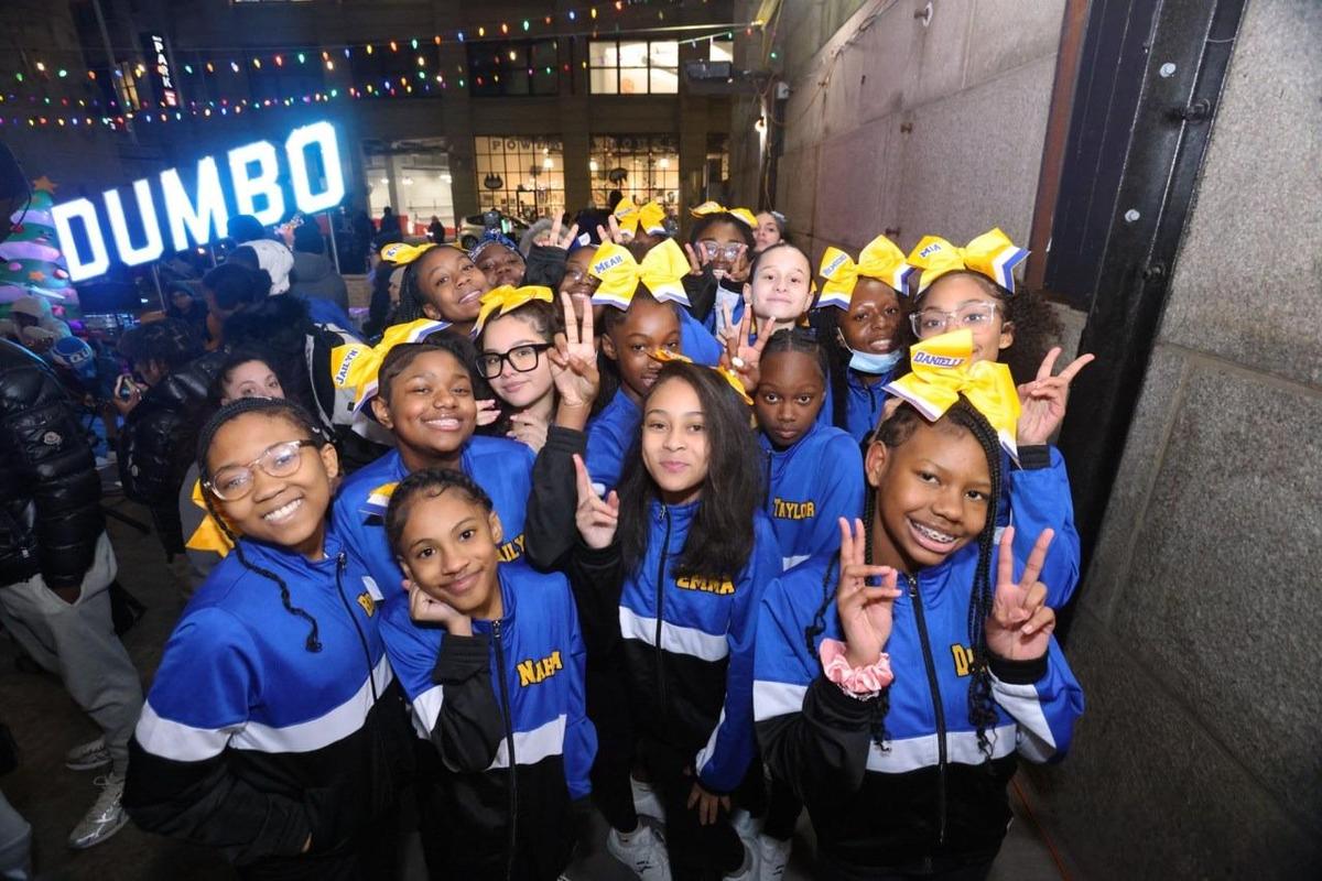Cheerleading team posing together, wearing matching outfits and bows.
