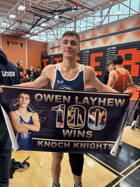 boy wrestler holding up sign that says 100 wins