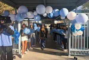 South Pointe Middle School ASB students line the campus gate to welcome students back to school.