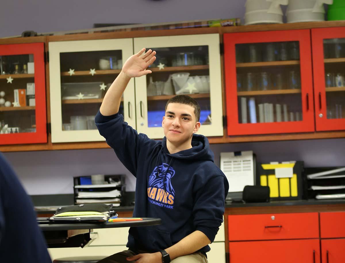 HSA McKinley Park student raising his hand in the classroom.