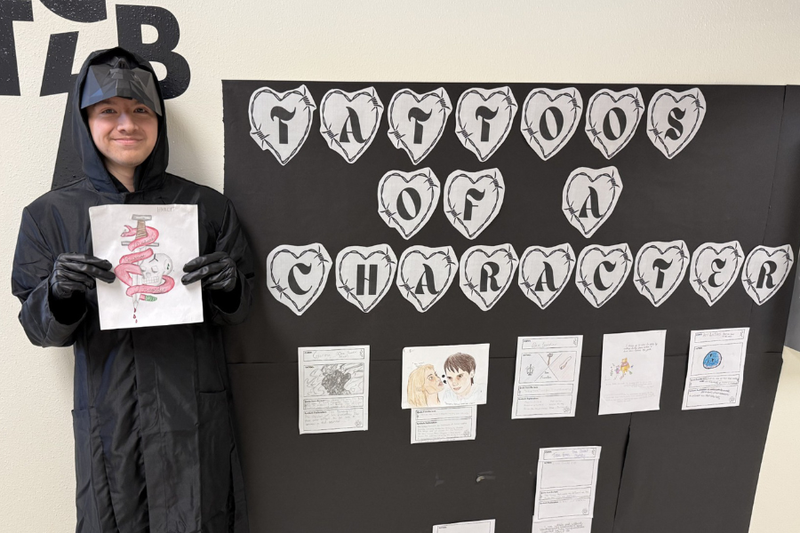 Andres Paiz holding up his winning tattoo design