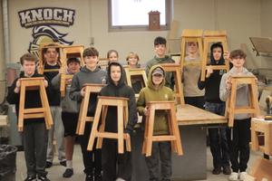 students holding stools they made