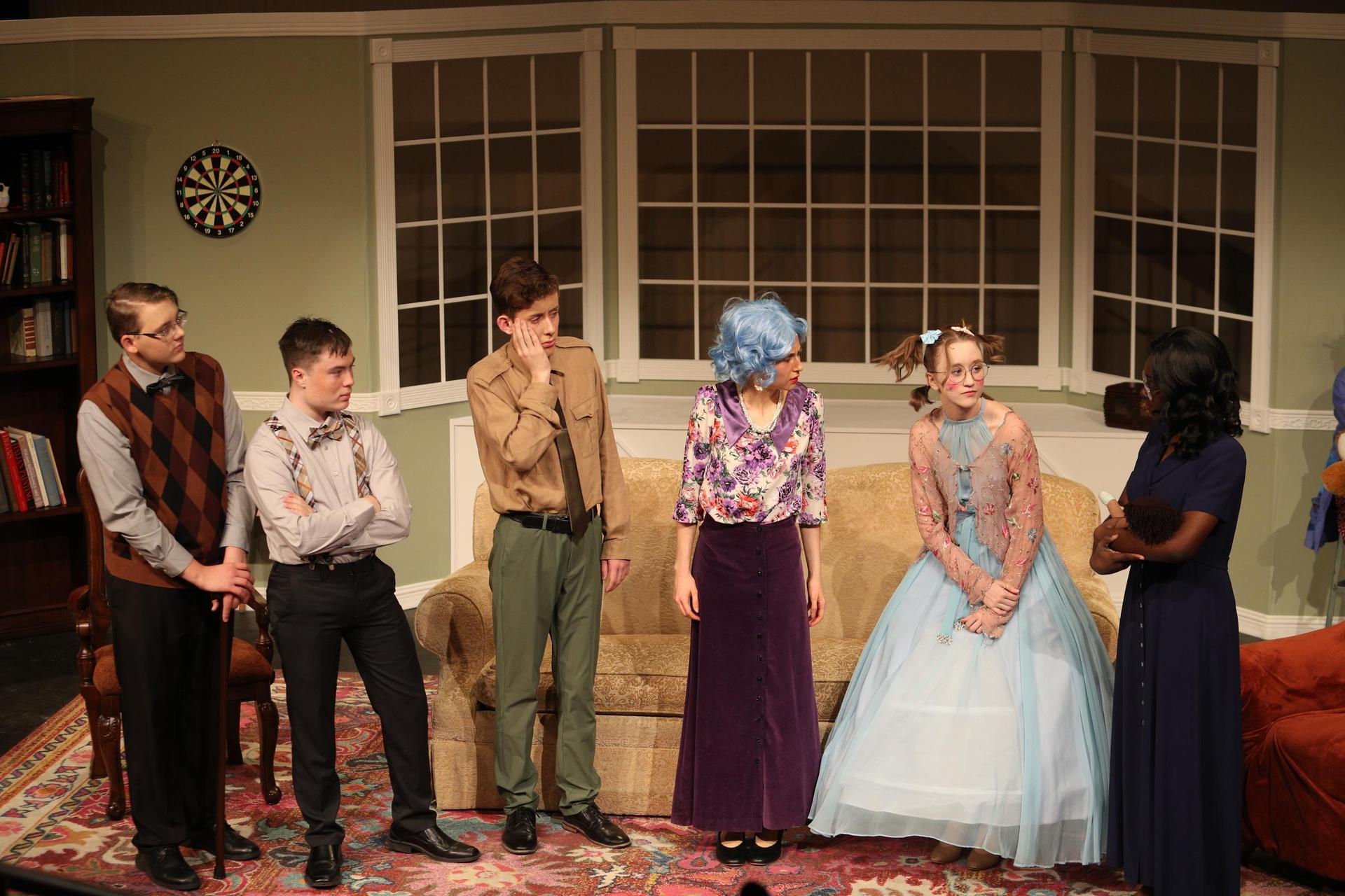 Characters standing around a room talking