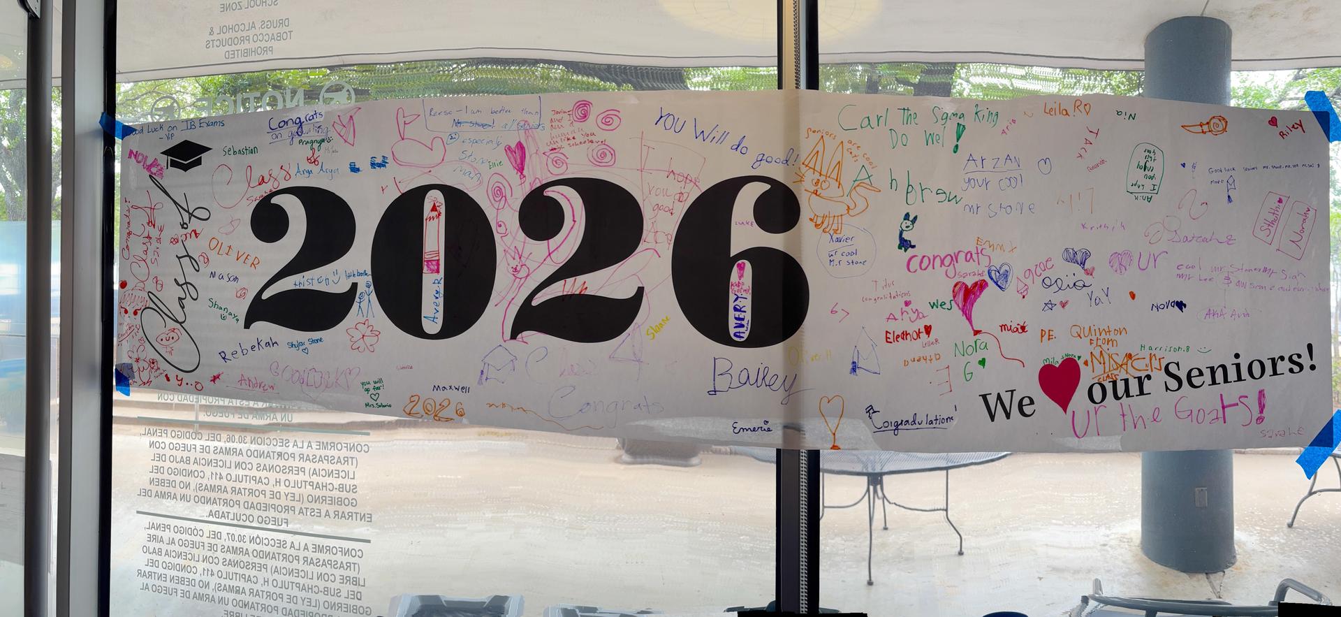 WHite banner that says "Seniors 2026" "We love our seniors" and signed by students