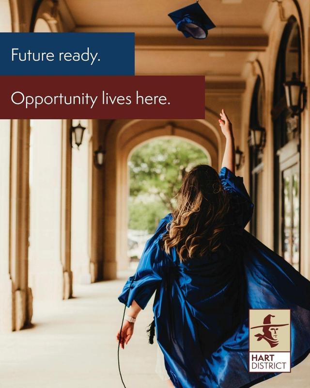 A girl in a blue graduation gown throwing a hat in the air.