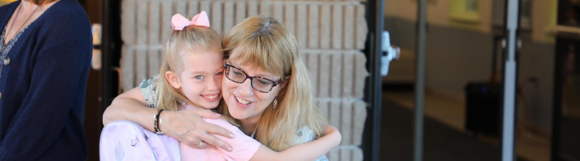 teacher hugging returning student