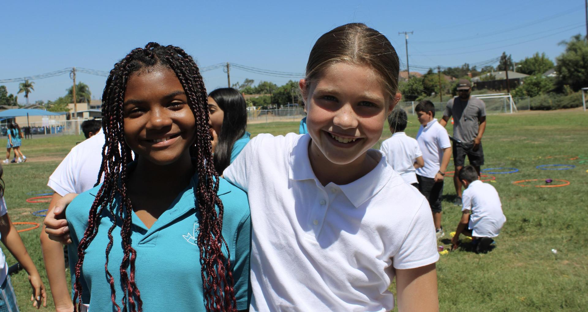 two girls smiling on field