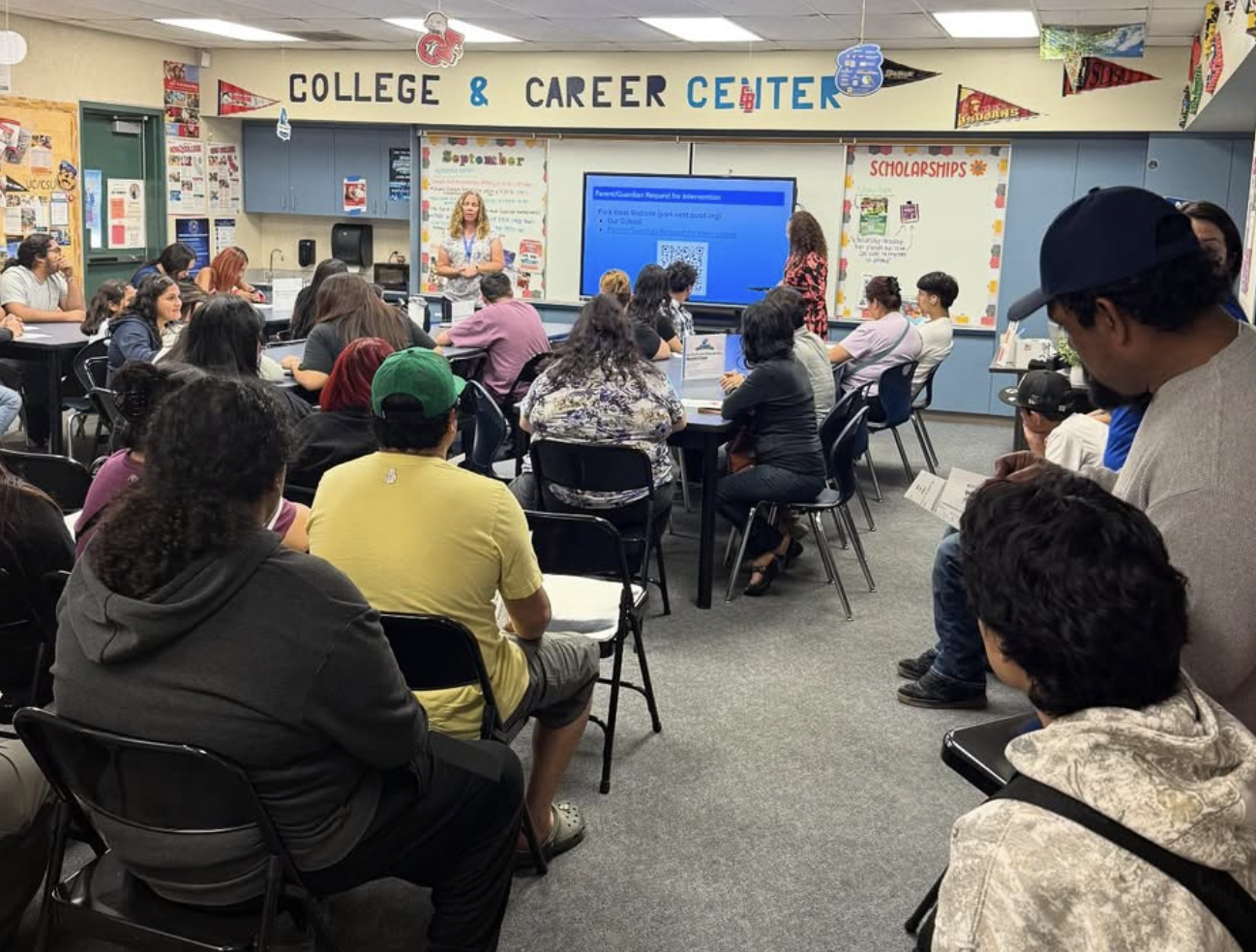 Park West Principal is speaking in front of a room full of parents in the career center.