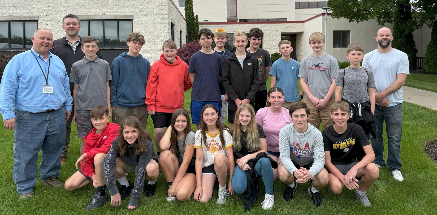 group of students and adults posing in front of a building