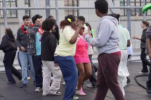 Another gathering of teens enjoying a lively dance party outdoors with colorful accessories.