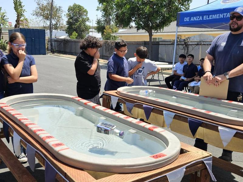 Students engaging in a water activity at an outdoor event.