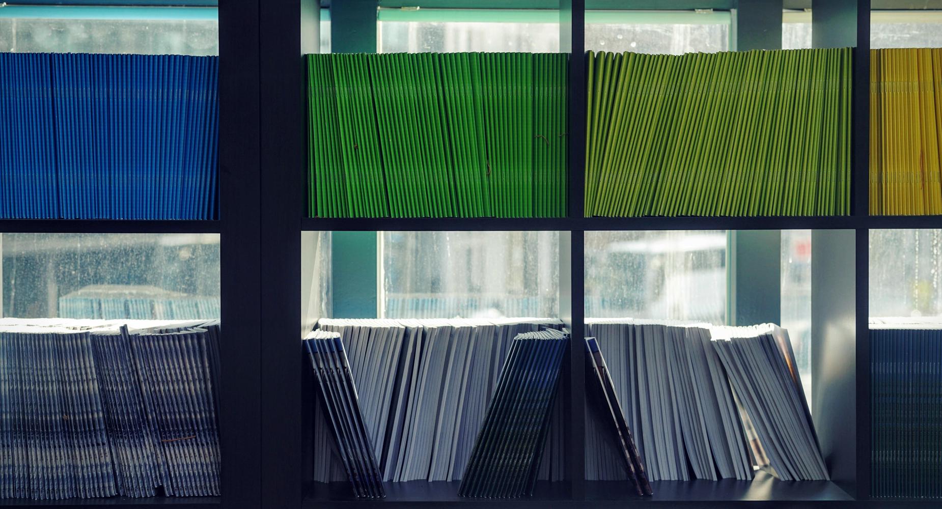 Shelves filled with colorful stacks of various books and magazines.
