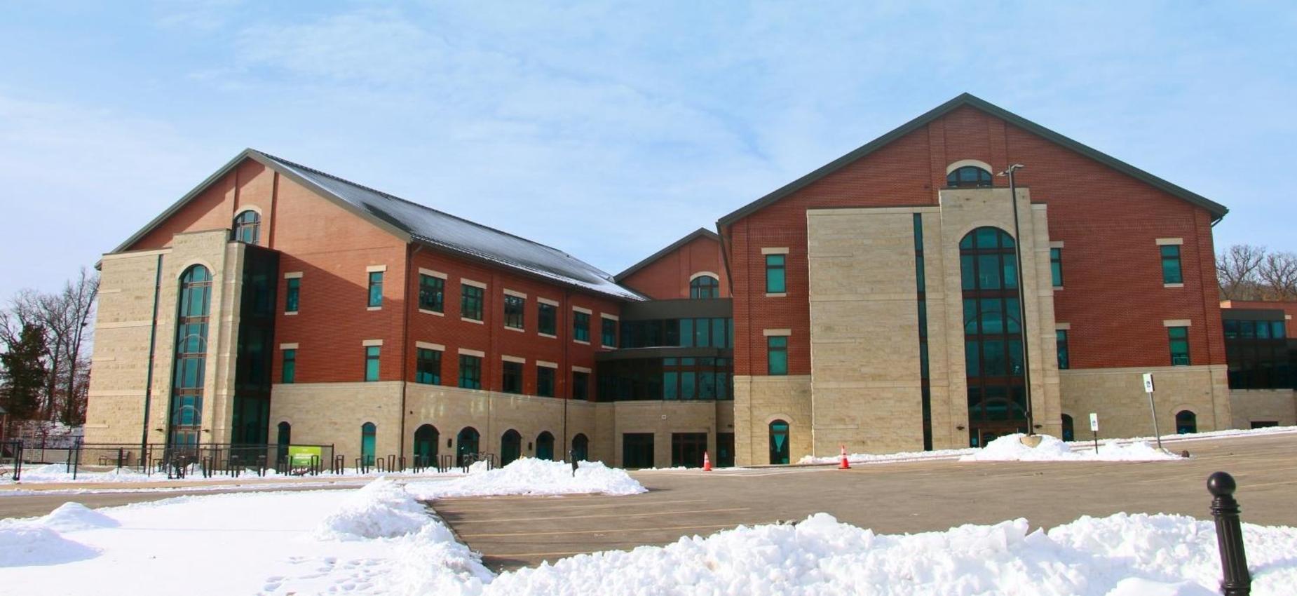 Snow-covered building displaying modern architecture on a clear winter day.