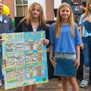 Students posing for picture with their Earth Day poster