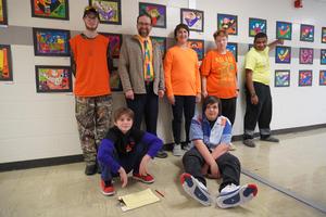 6 student and art teacher mr. vandenburgh in front of the artwork