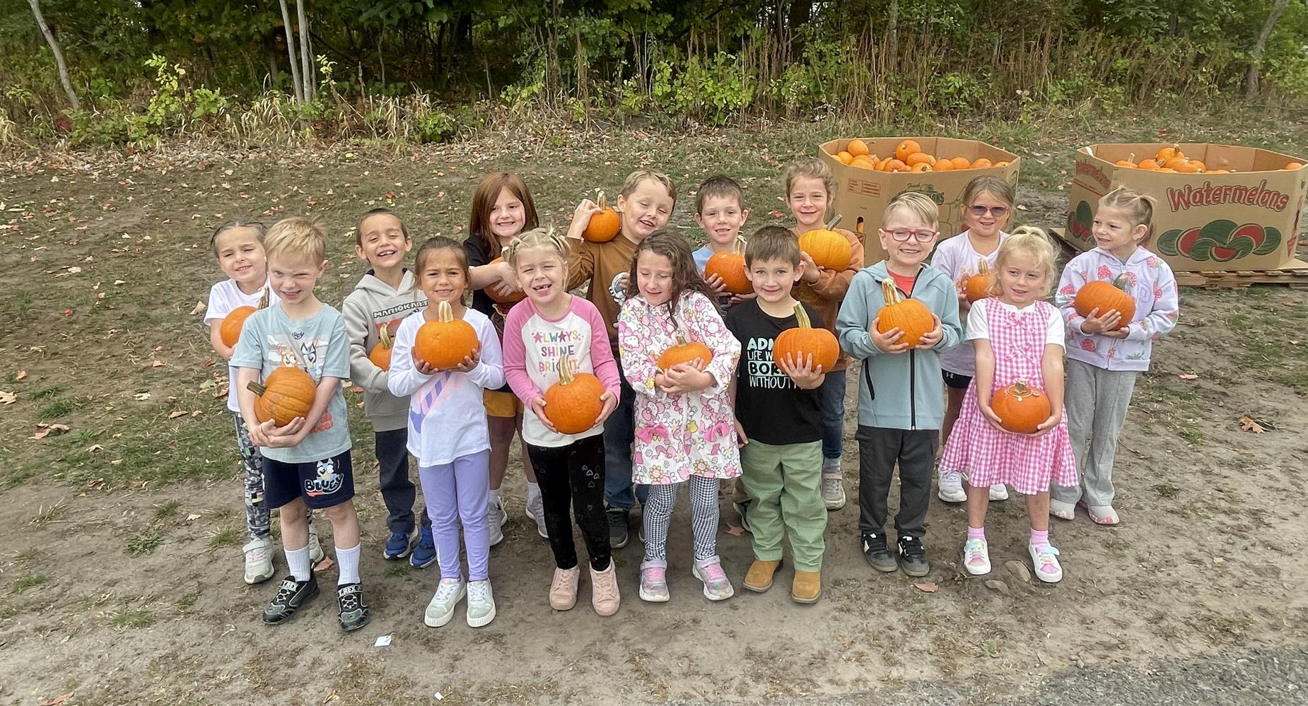 MCS students hold pumpkins.