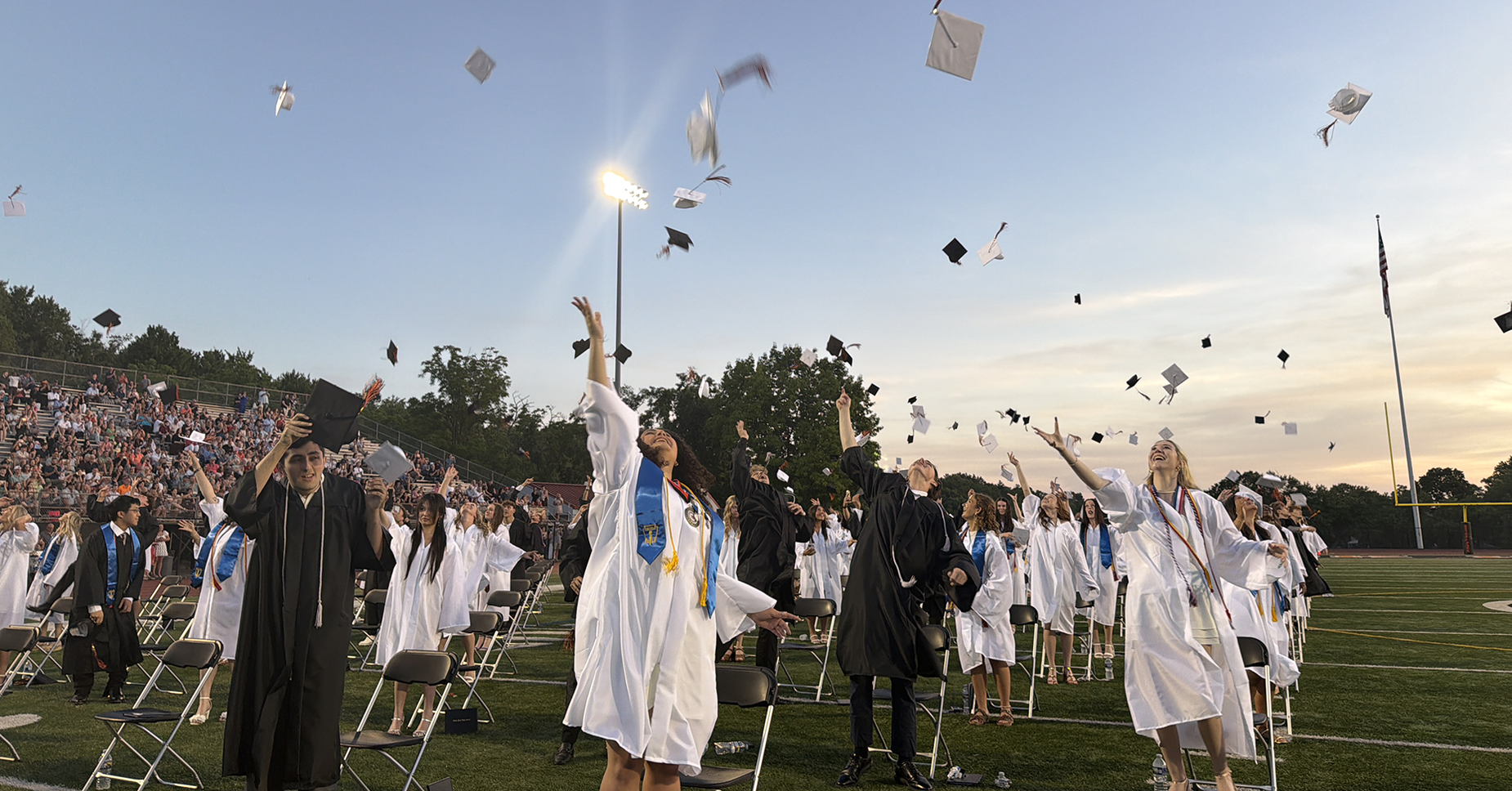 Graduates toss their caps in celebration during a graduation ceremony.