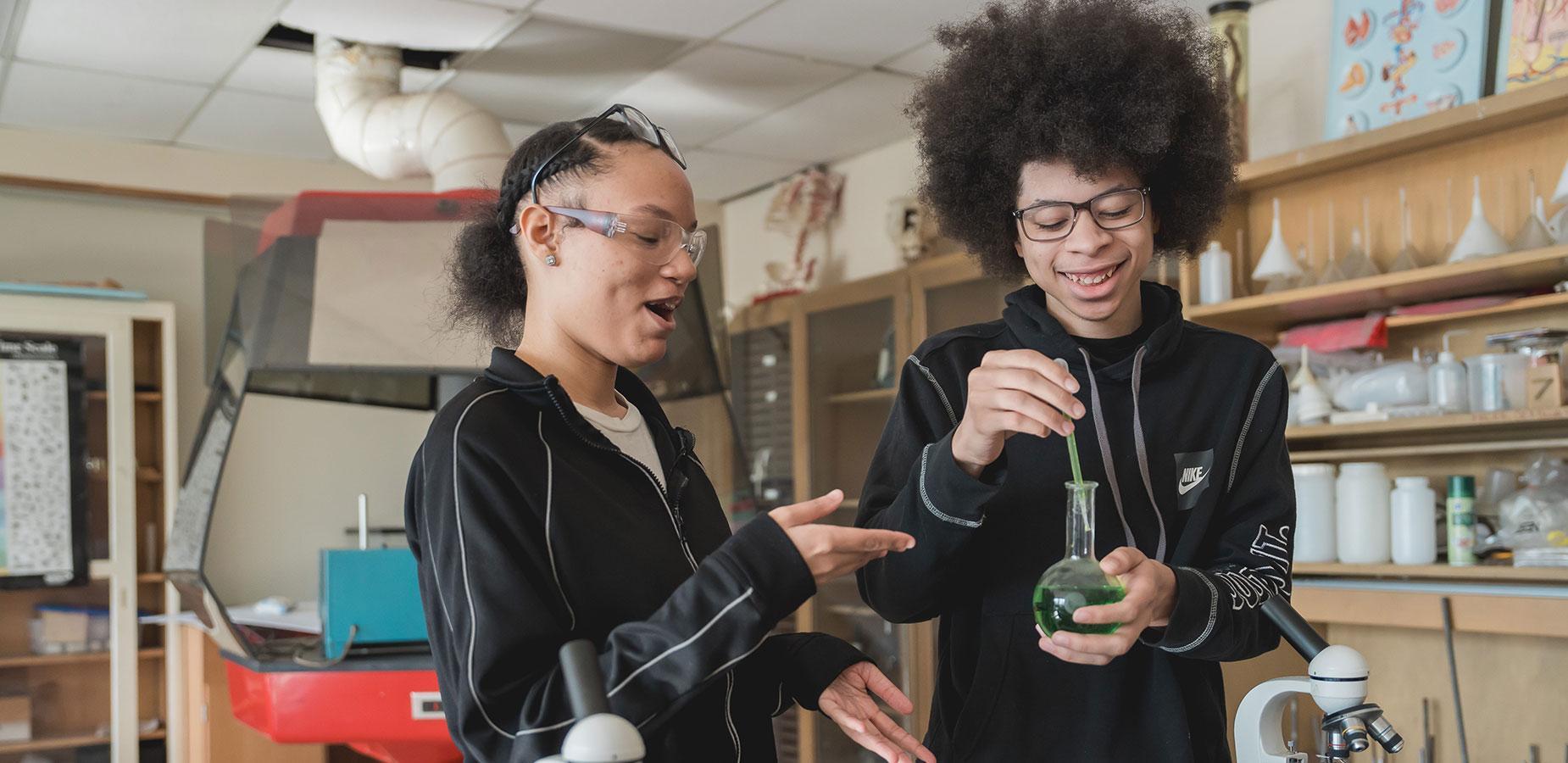 high school students working with chemistry experiment