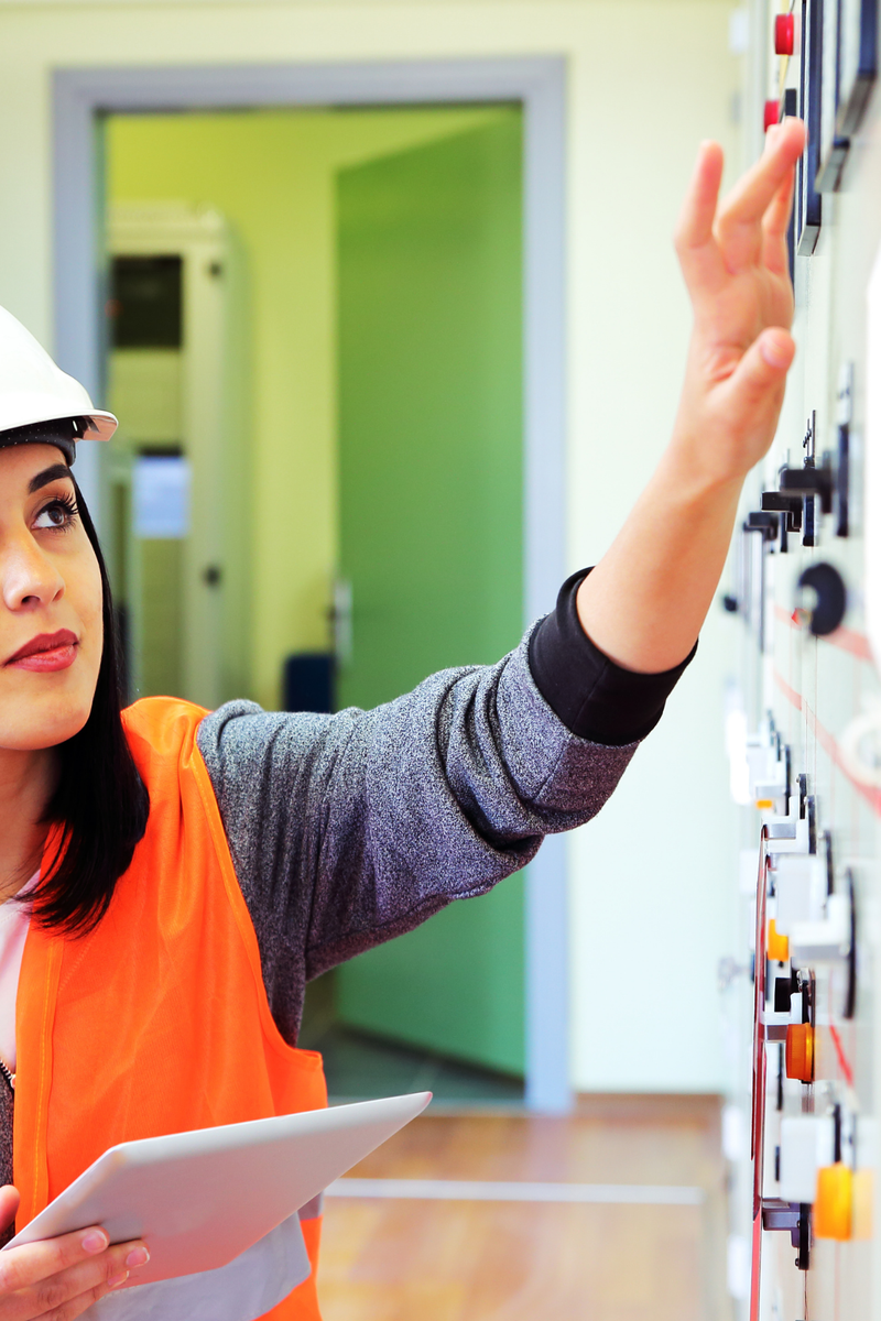 Female electrician working on an electric panel