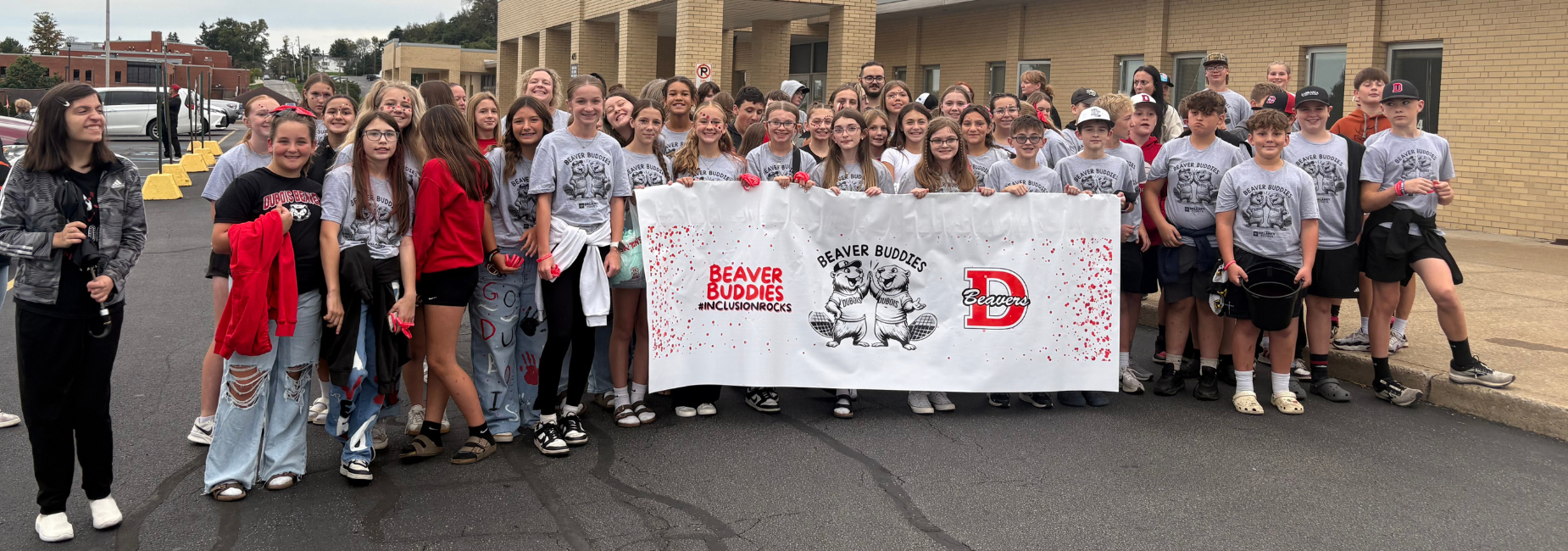 Group of students holding a banner promoting Beaver Buddies.