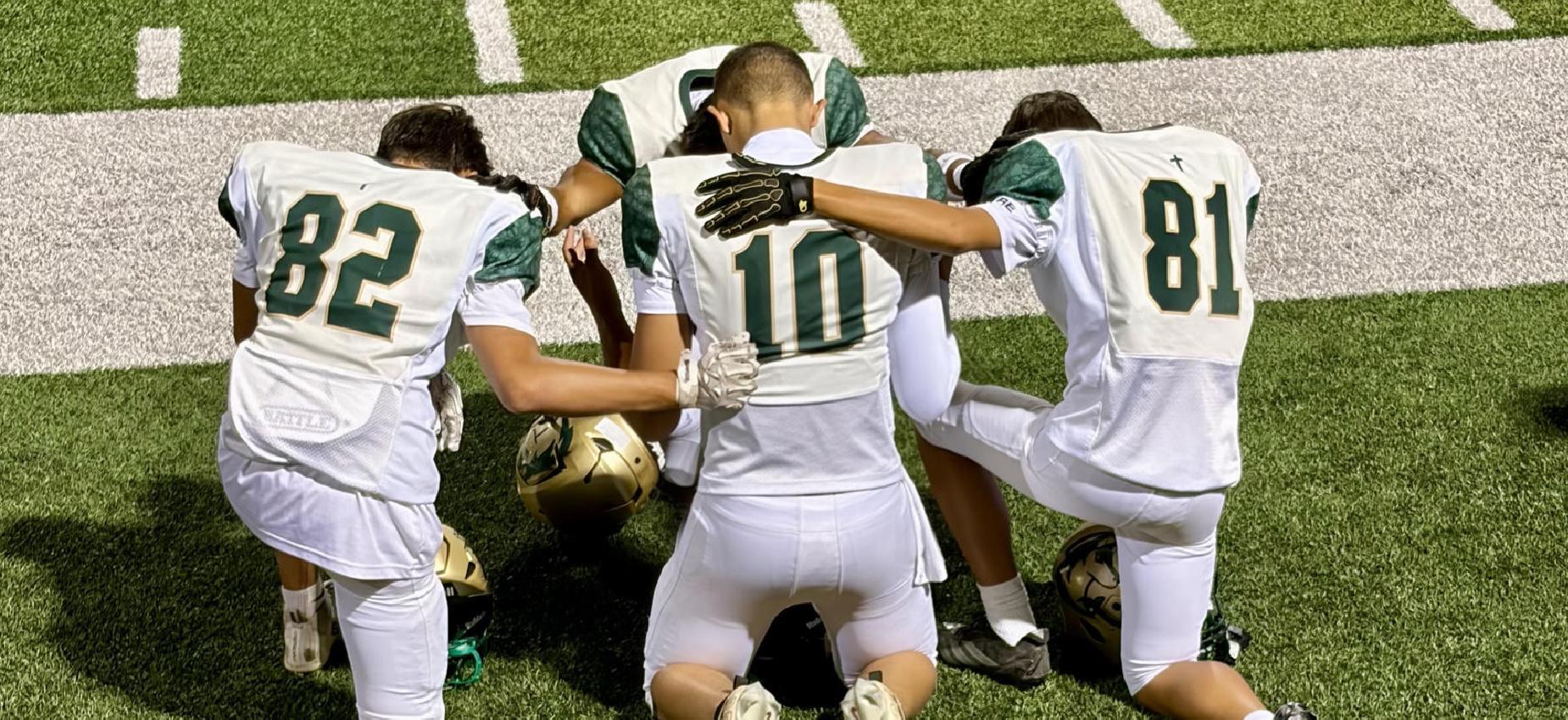 HOPE football players kneel together in prayer on the field in an undefeated season, knowing their talent is from the Lord.